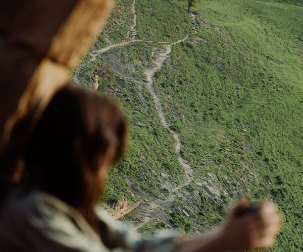 Person meditating outdoors with a serene landscape background.